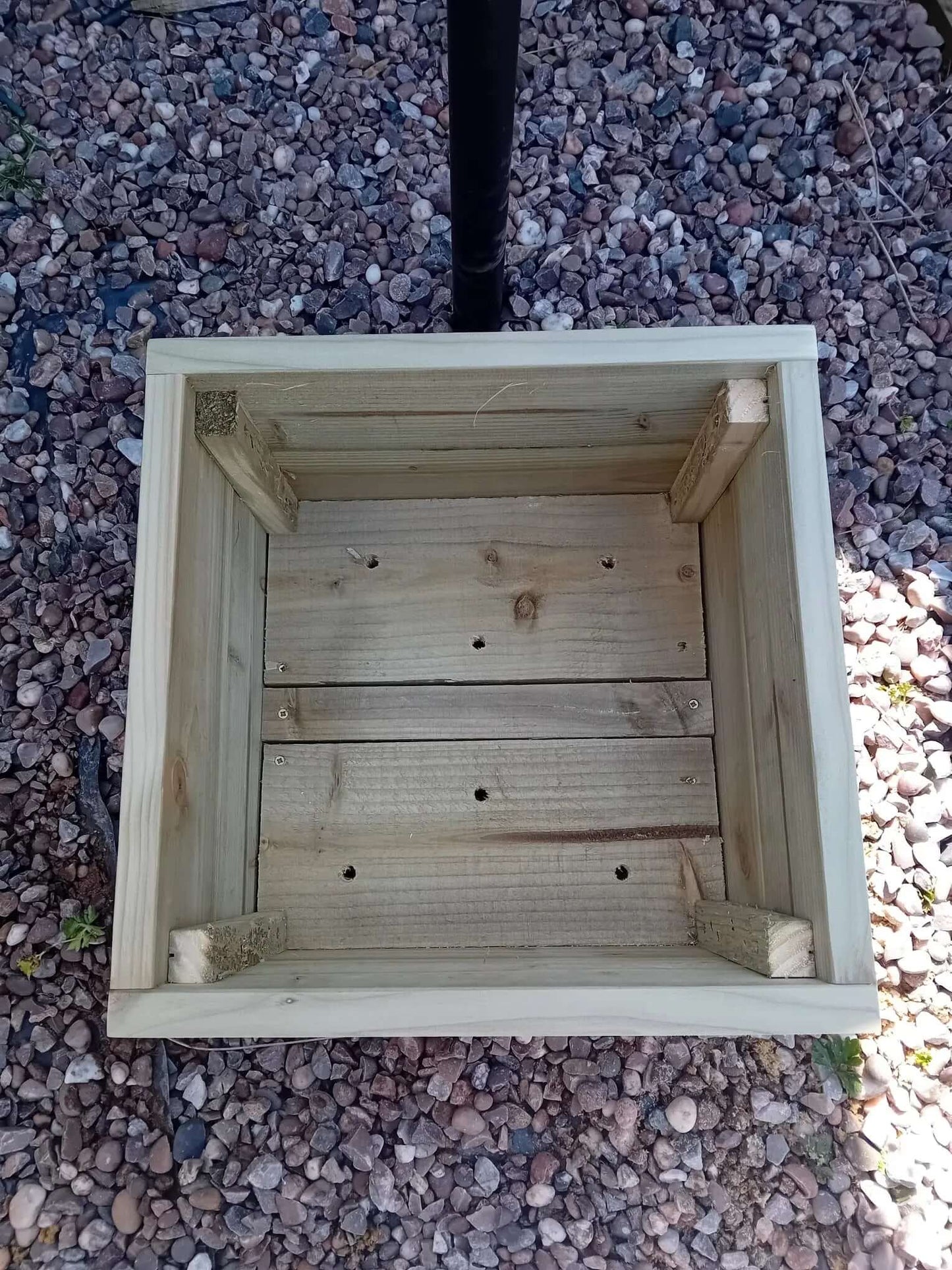 Inside view of square gardening planter with drainage holes