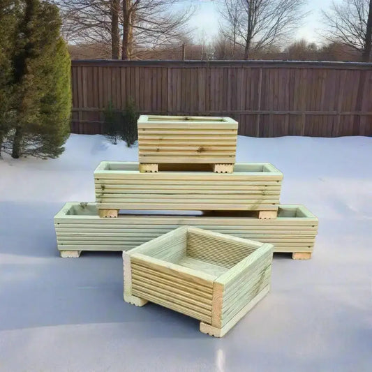 How to protect wooden planters Through the winter with stacked wooden planters on snow-covered ground.